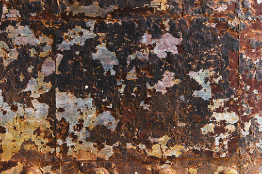 Peeling dark paint on rusty metal texture background