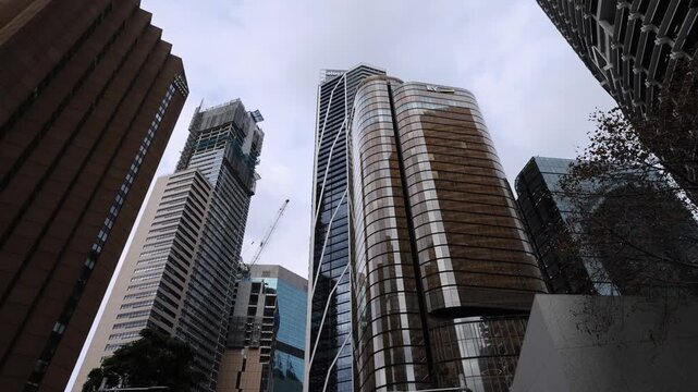 View of modern skyscrapers and glass office buildings in the central business district with street traffic and urban infrastructure in Sydney, New South Wales, Australia.