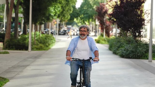 Senior man riding bicycle in the street. Active retired urban lifestyle