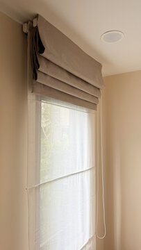 Luxury roman blinds with white sheer curtain on a condominium window