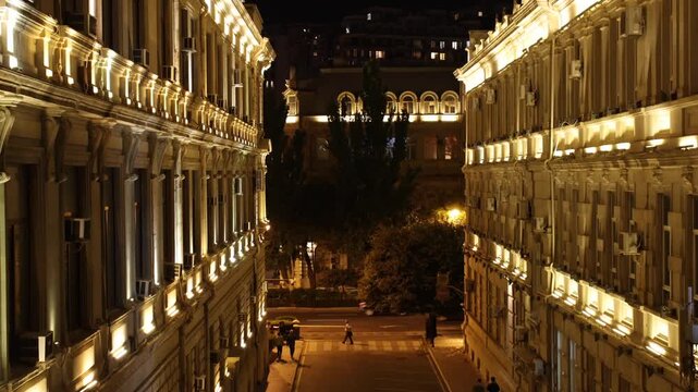 View of illuminated historic buildings lining a street at night in Baku, Baku, Azerbaijan.