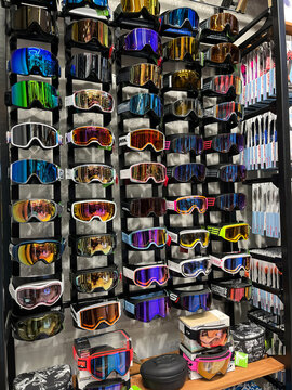 A display wall featuring a variety of colorful ski goggles arranged neatly. The goggles showcase different lens colors and designs. This setup is ideal for winter sports enthusiasts.