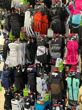 A clothing store interior features a variety of jackets, coats, and activewear displayed on racks. The color scheme includes shades of blue, black, red, and white.