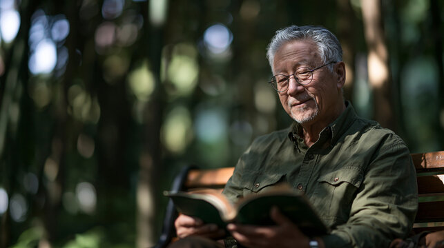 Senior Asian Man Reading Book on Park Bench