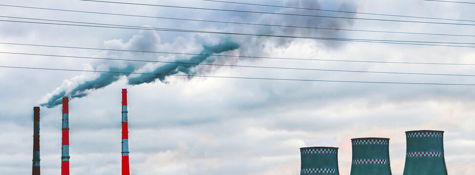 Environmental pollution, environmental problems, smoke from pipes and cooling towers of an industrial enterprise or thermal power plant against the background of a gray cloudy sky