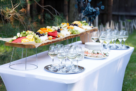 A banquet table set with appetizers and fruit, a buffet for an outdoor celebration, and on-site catering services