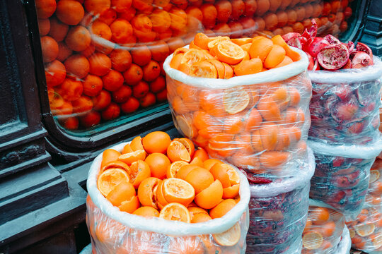 bags of squeezed oranges beside a shop window