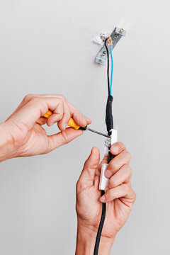a man connects the electrical cord of a ceiling light