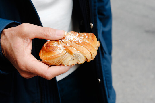 a man holds a traditional Swedish kanelbulle