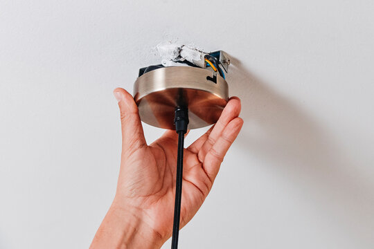 a man positions a ceiling light canopy on the ceiling
