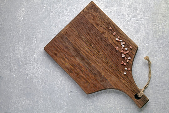Rustic Wooden Cutting Board with Himalayan Salt on Grey Concrete