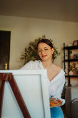 Woman painting art on canvas with easel at home © Dusan