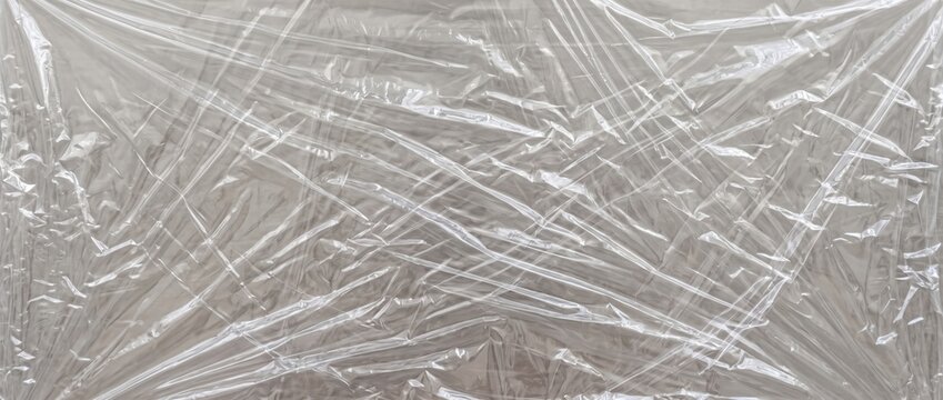 Wrinkled clear plastic wrap texture. Close-up of crumpled transparent cellophane food film stretch layer