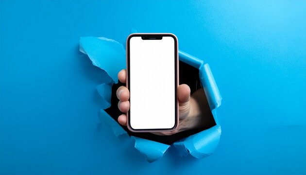 a hand holding an iphone with a blank white screen emerging through torn blue paper background