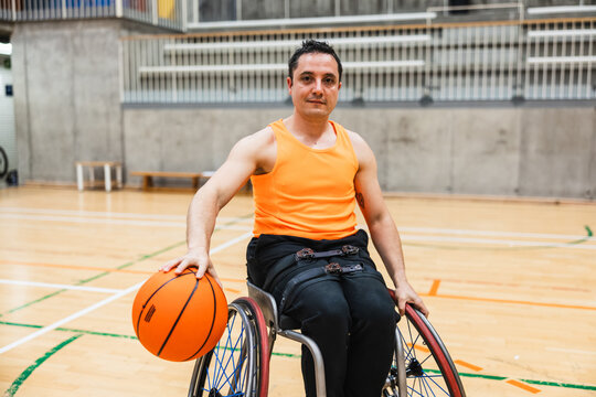 Male athlete playing wheelchair basketball on court