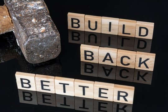 Holzbuchstaben neben einem Hammer zeigen die Worte BUILD BACK BETTER