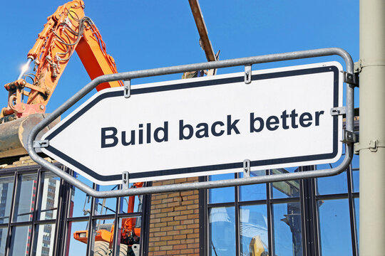 (Fotomontage) Richtungspfeil mit der Aufschrift BUILD BACK BETTER vor einem Abrissbagger