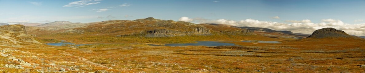 Enontekio, Finland - 28.08.2026: Vast arctic tundra landscape with small blue lakes and rocky hills under a cloudy sky in Lapland © Andrei