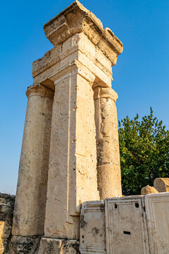 Ancient Roman stone column structure in ancient city ruins under clear blue sky
