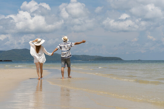 Couple walking hand in hand on a tropical beach