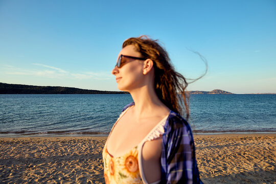 Carefree woman enjoying the sea breeze on a sunny beach