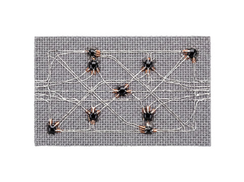 Smart textile wearable technology circuit woven with conductive thread and electronic components on gray fabric for innovative IoT smart clothing design and engineering prototype research concept.