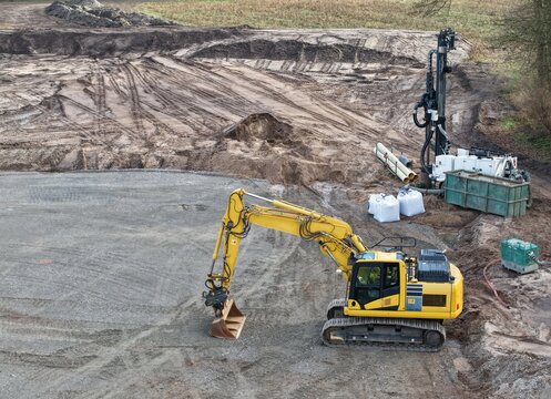 Bagger und gro&szlig;e Pumpen zur Grundwasserabsenkung auf einer Baustelle f&uuml;r eine Windkraftanlage, Luftbild