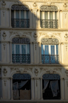 Close-up of ornate French colonial building facade with wrought-iron balconies and lace curtains, North Africa, Algiers, Algeria