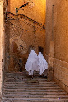 Mozabite women in white ha&iuml;k in the streets of Ksar El Atteuf, North Africa, Ghardaia, Algeria