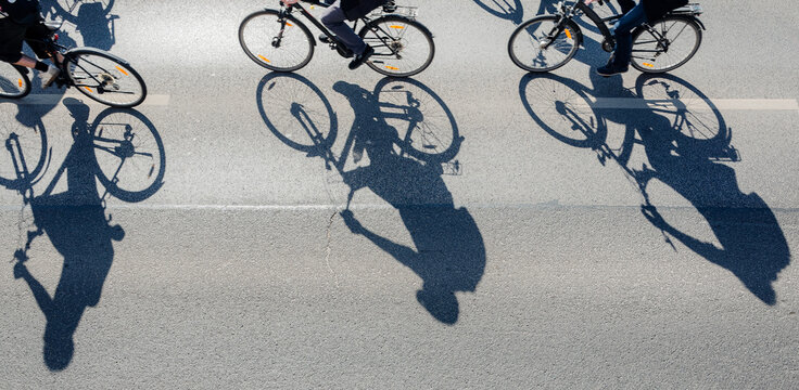 Aerial View of Cyclists Riding on Asphalt with Long Sun Shadows