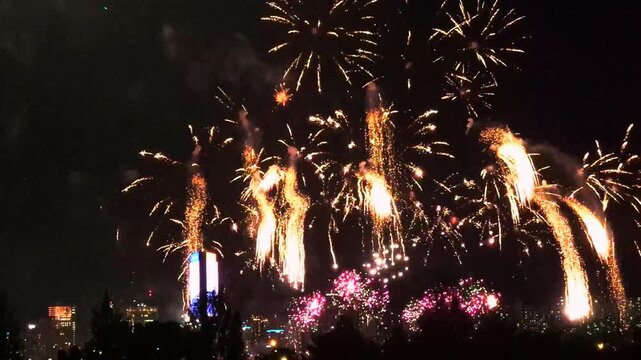 Long continuous sequence of a fireworks festival over the Seoul city skyline at night, with floating orange stars above the Han River in South Korea