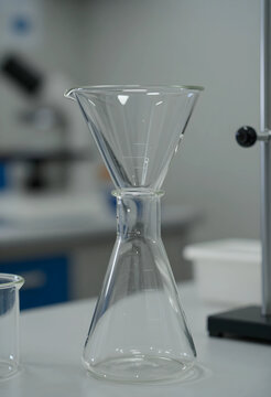 Scientific research and laboratory analysis, glass funnel and conical flask equipment for chemical experiment in a modern medical or pharmaceutical facility