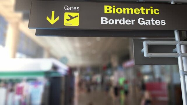 Digital sign showing the direction to the biometric border gates at an airport, introducing a new automated control system for passengers' identity verification and contactless travel