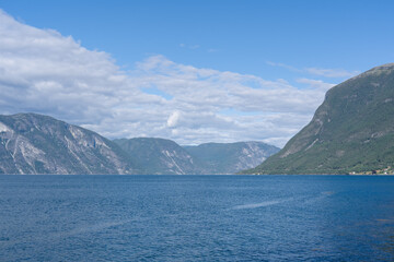 Obraz premium Scenic Norwegian fjord landscape with calm blue water and towering mountains