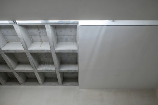 Coffered concrete ceiling in a bare modern interior &ndash; Ideal for architecture portfolios, interior design features, or construction branding