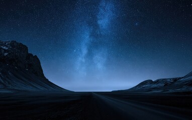 Obraz premium Dark, barren terrain under a vast, star-filled night sky with Milky Way
