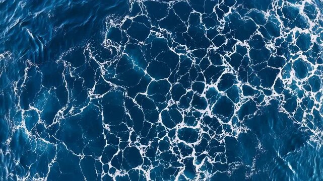 Top View of White Sea Foam on Deep Blue Ocean Water