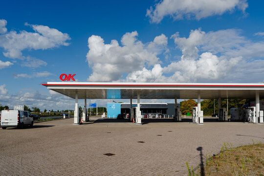 August 21, 2026, Amsterdam, Netherlands - OK gas station with fuel pumps and an AH to go store under a blue sky