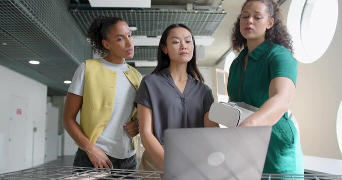 Three Female Design Professionals Working on Project Together, using Laptop and VR headset