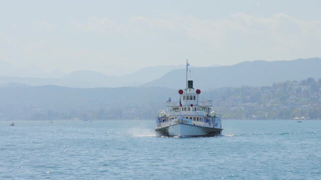 Historic paddle steamer boat cruising on blue lake