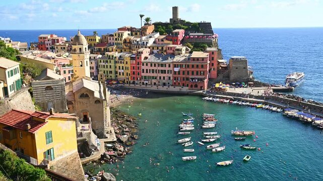 Colorful coastal village boats bobbing in small harbor on mediterranean shore. Vernazza, Italy