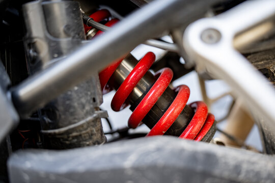 Motorcycle rear shock absorber with coil spring mounted inside the chassis structure, illustrating suspension components and mechanical inspection of a touring motorcycle