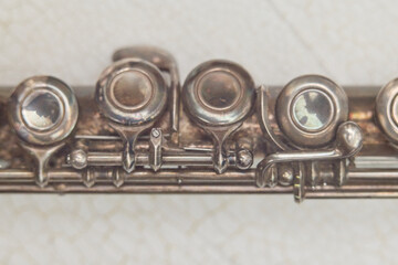 Vintage flute close up with metal keys and blurred musical instrument details © Lumae Nord
