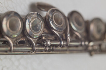 Vintage flute close up with metal keys and blurred musical instrument details © Lumae Nord
