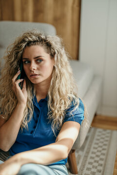 Young woman having concerned conversation on mobile phone