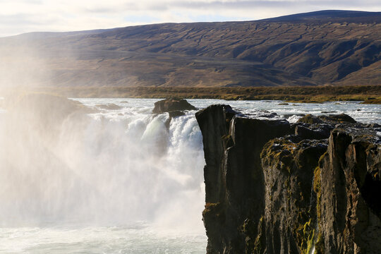 Powerful waterfall plunging over a dramatic volcanic cliff in Iceland