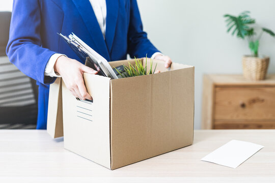 Unemployed, quite job. Desperate asian young businesswoman resigning from company, hand holding cardboard, packing belongings, stuff into box, layoff or changing work. Resignation, employment concept.