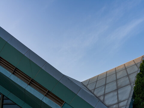 Modern geometric building roof edge against blue sky