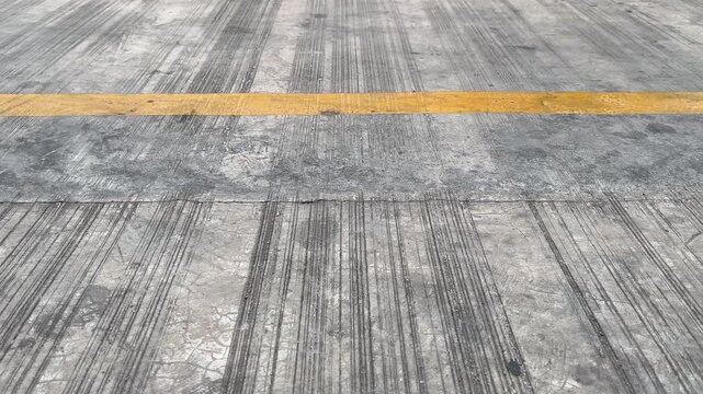 Yellow line road marking on textured concrete pavement background
