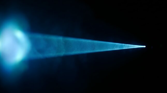 Intense blue light beam cutting through darkness with a glowing blurred source